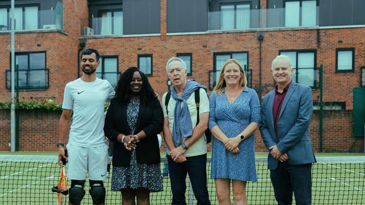 Five people on court stood in front of the net