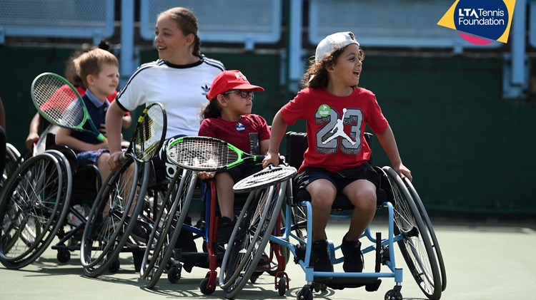 A group of children playing wheelchair tennis