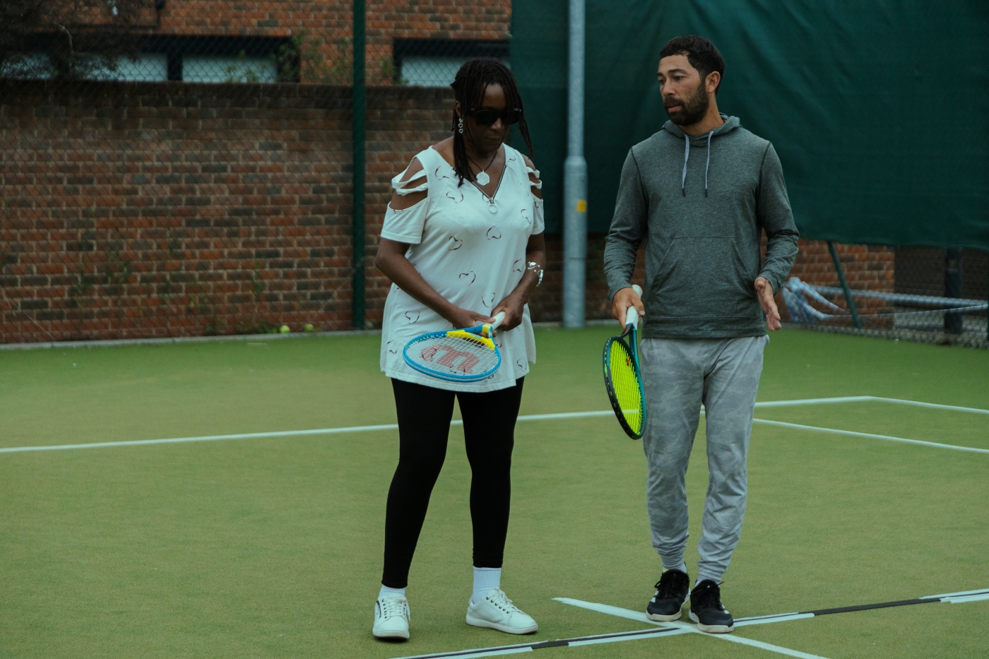 Two people holding rackets on court