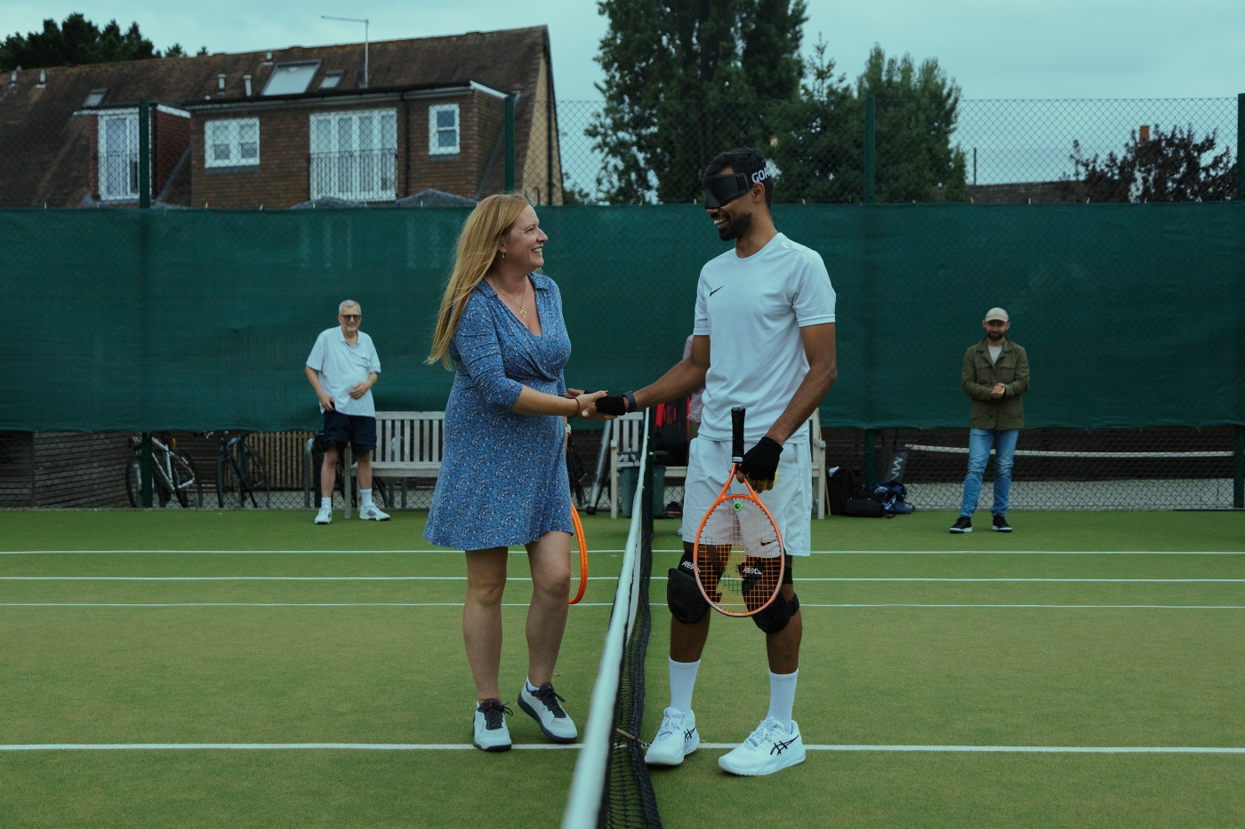 Two players shaking hands at the net