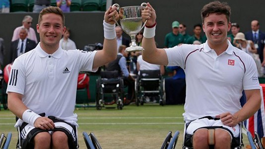 Alfie Hewett and Gordon Reid both smiling and holding a trophy