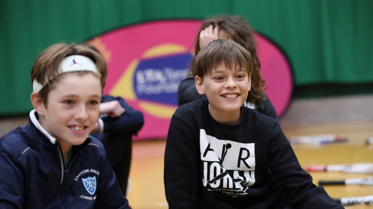 Two boys sitting down and smiling