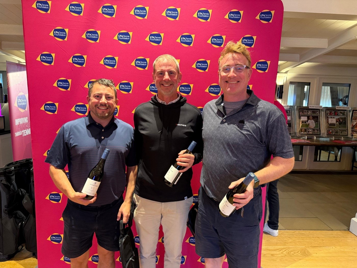 Winners of the Golf Day, holding their bottles of Nyetimber