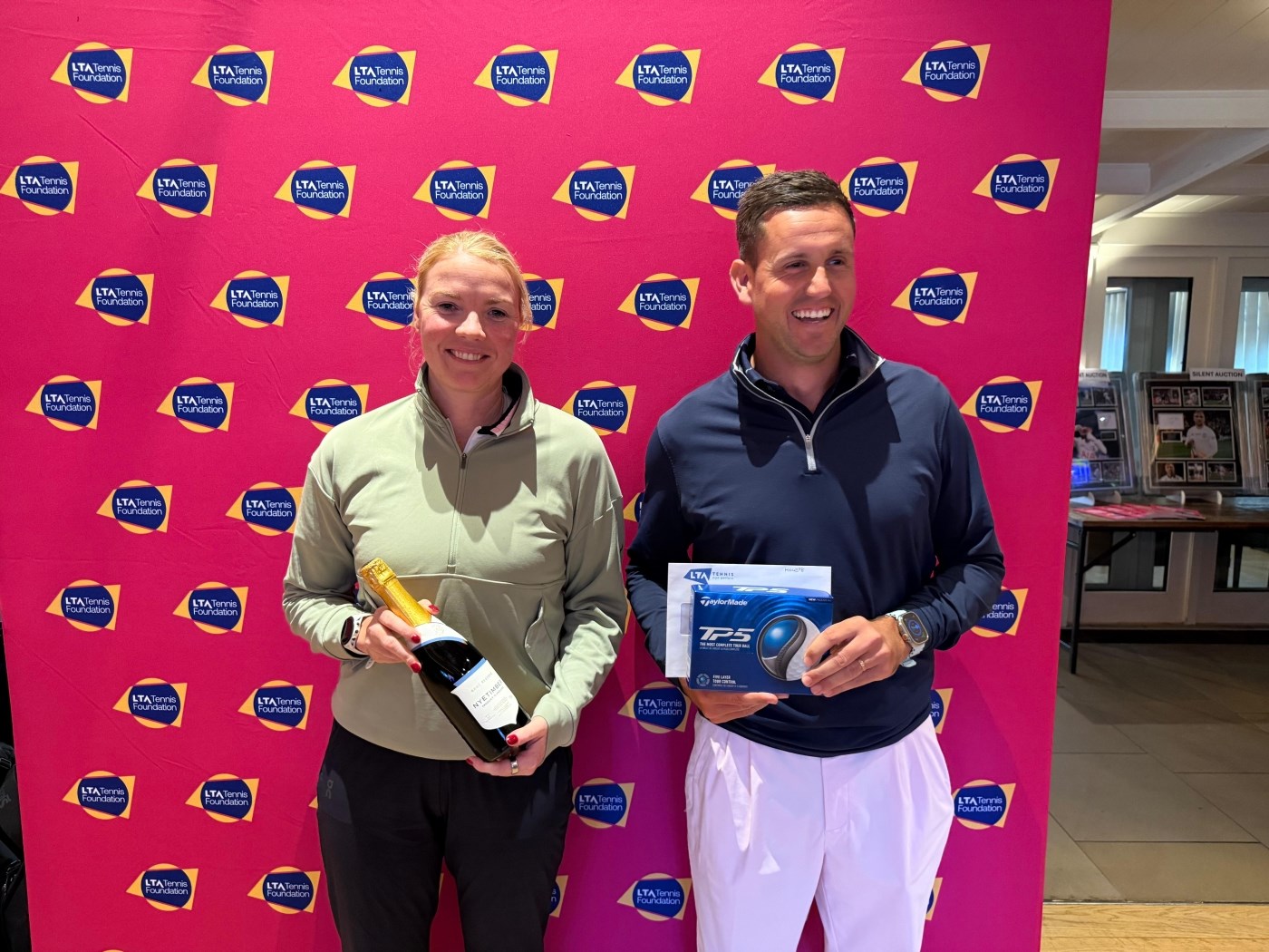 Two winners of the Longest Serve competition, holding their prizes and smiling.