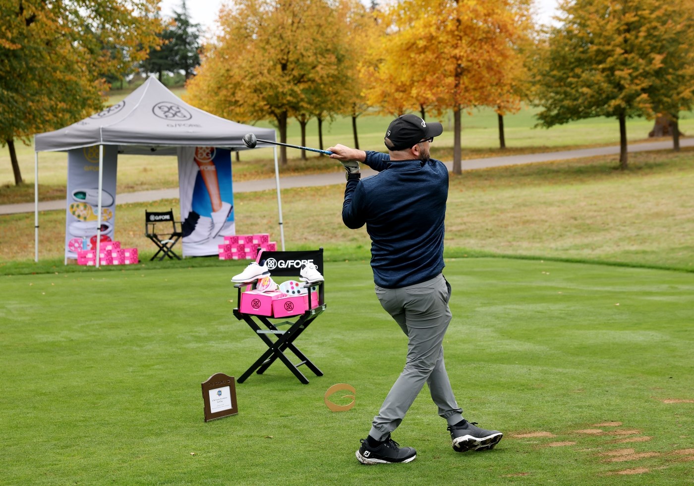A man with his golf club held behind him, just after teeing off