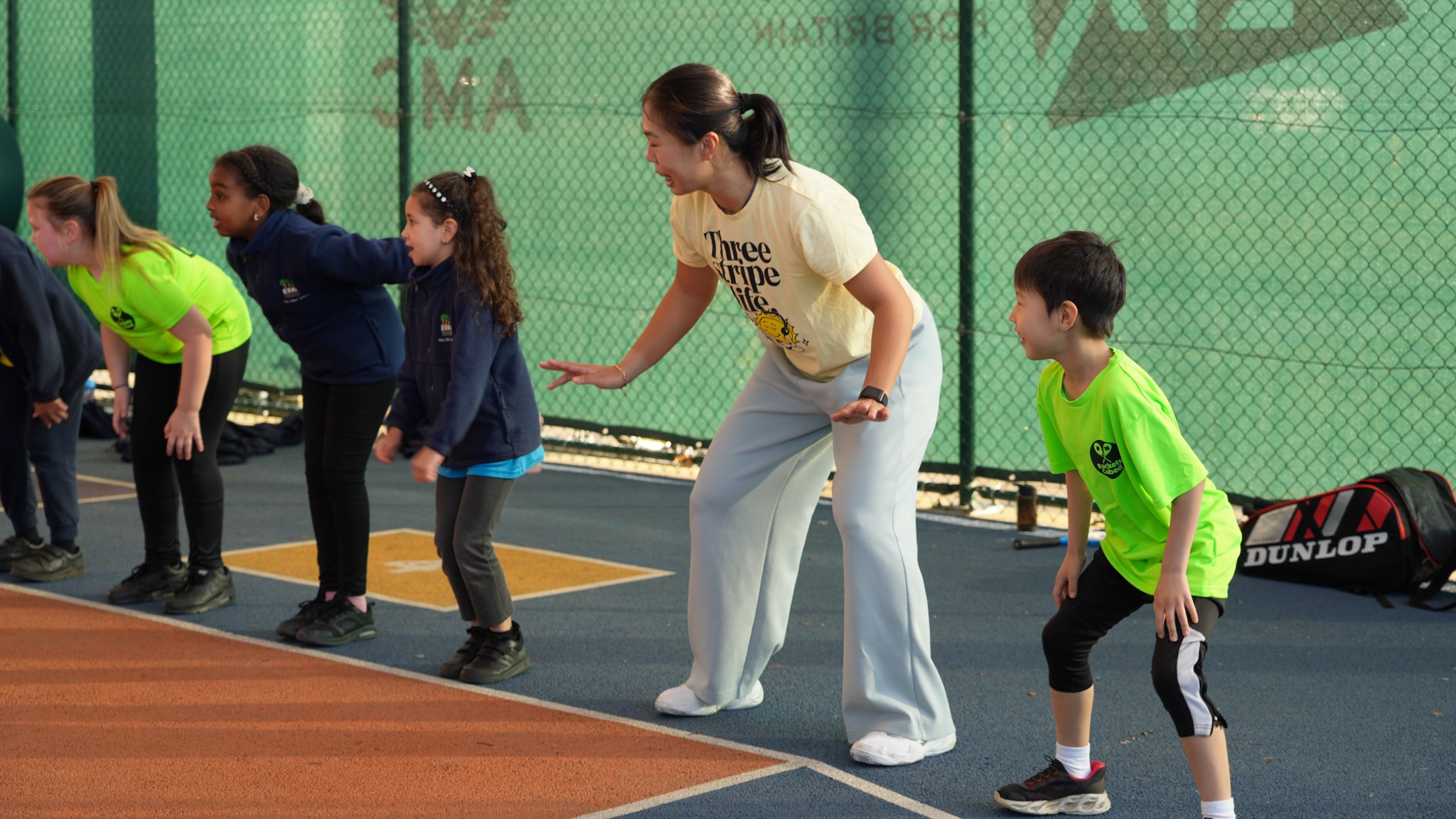 5 young people in the ready position on the baseline
