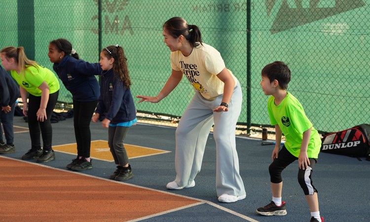 5 young people in the ready position on the baseline