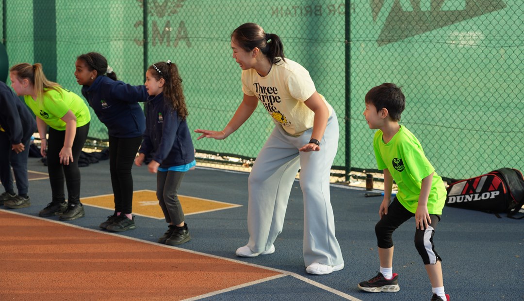 5 young people in the ready position on the baseline