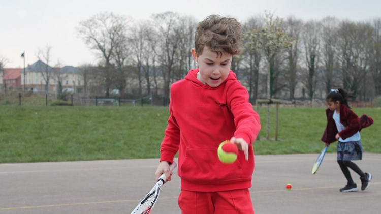 Primary school student enjoying tennis session 