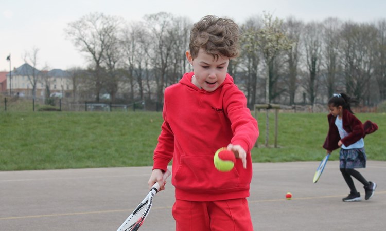 Primary school student enjoying tennis session 