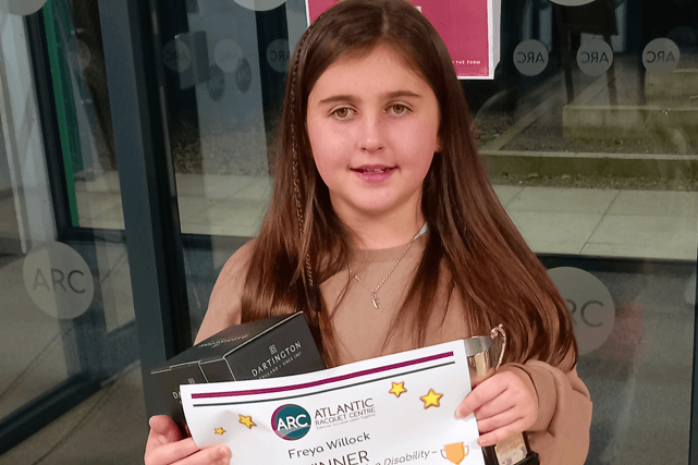 Freya smiling while holding up an ARC Awards certificate