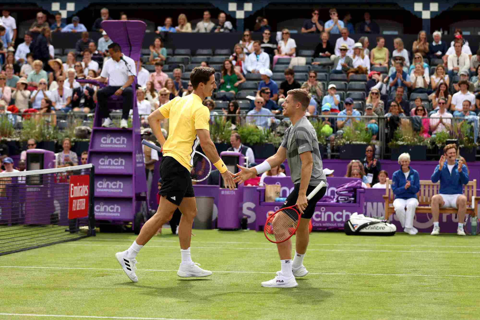 Neal Skupski and Joe Salisbury high-fiving each other on court at the cinch Championships during the fan day exhibition match