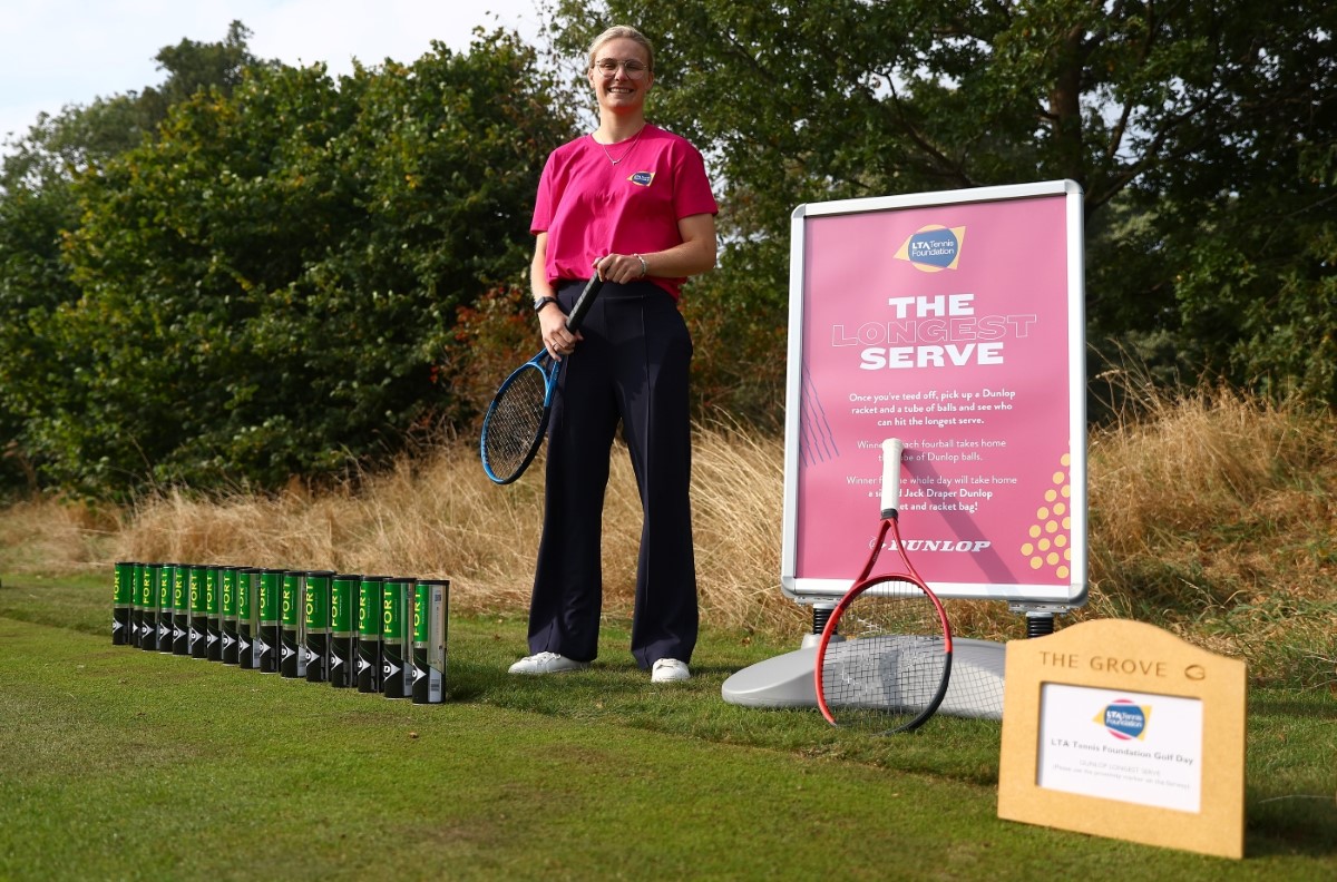 A volunteer standing next to a 'The Longest Serve' poster