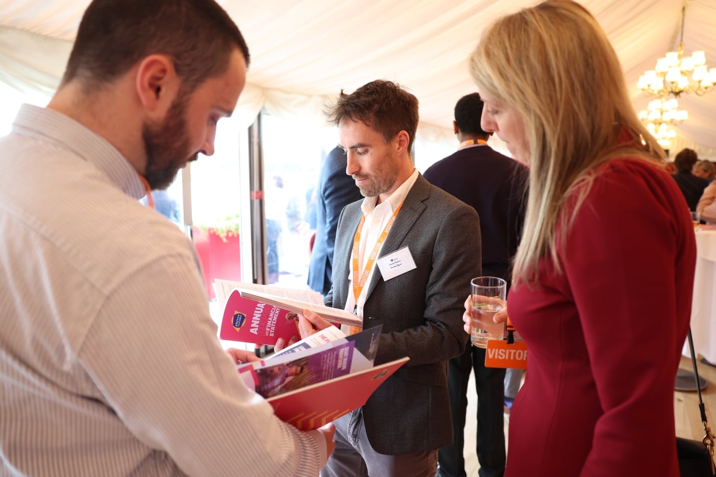 Reception attendees review the annual report brochure