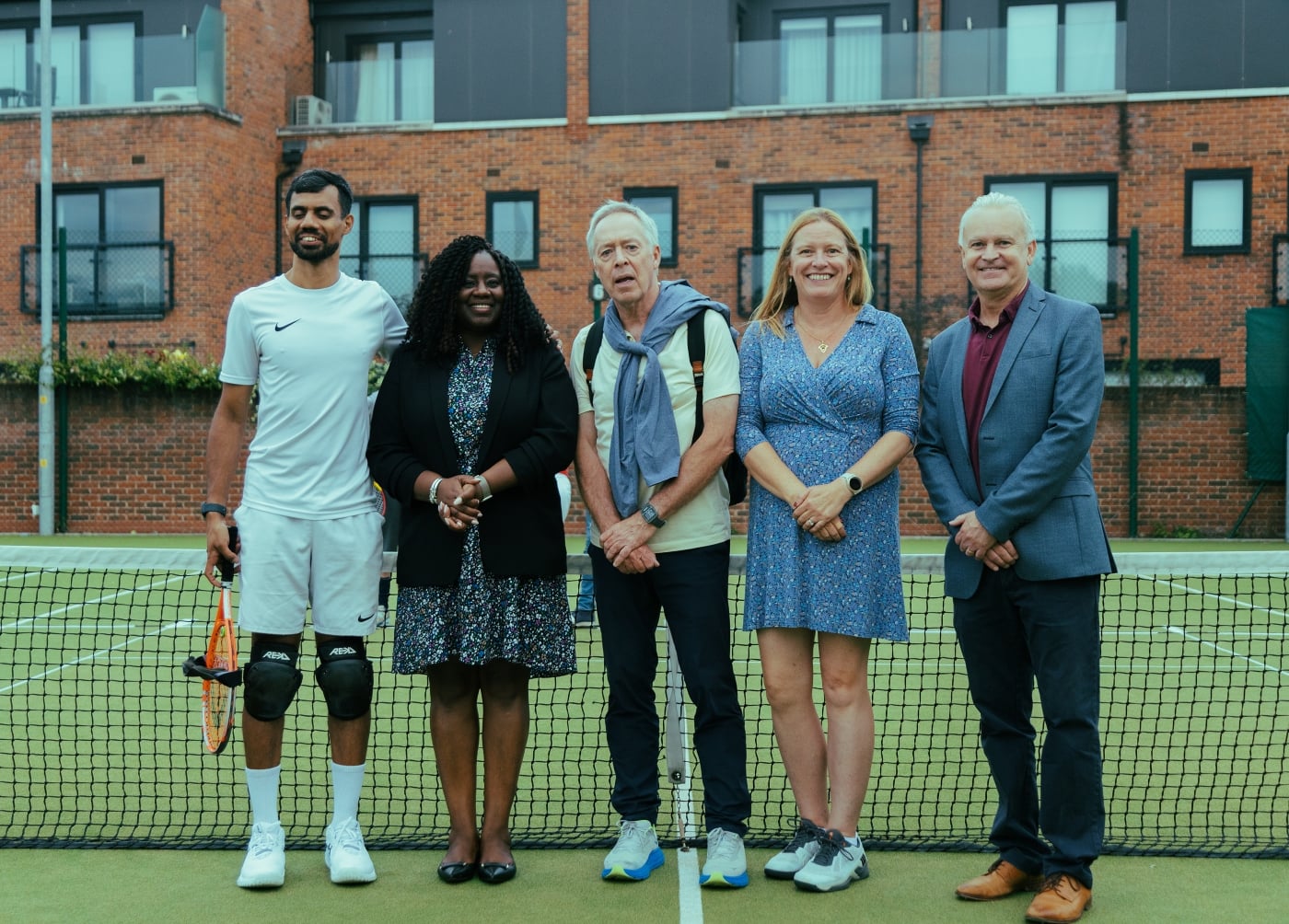 Five people on court stood in front of the net