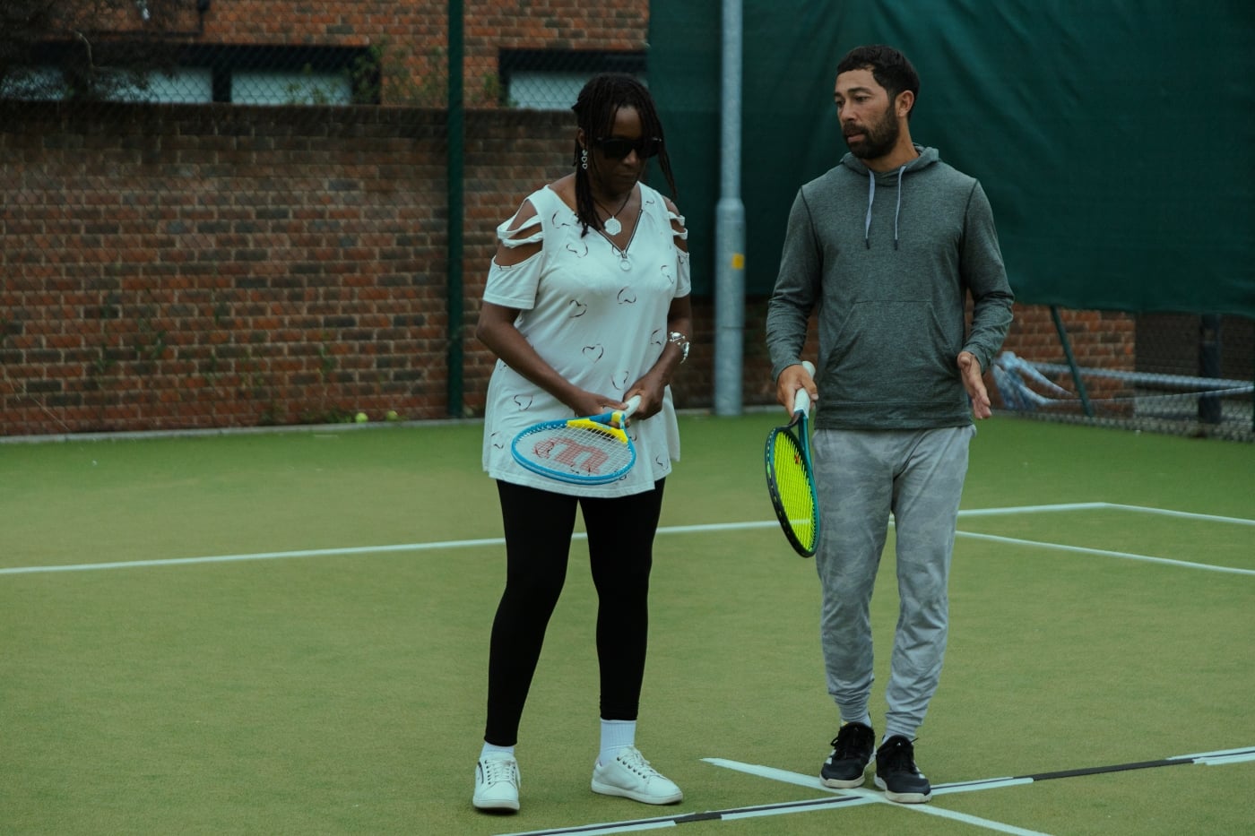 Two people holding rackets on court