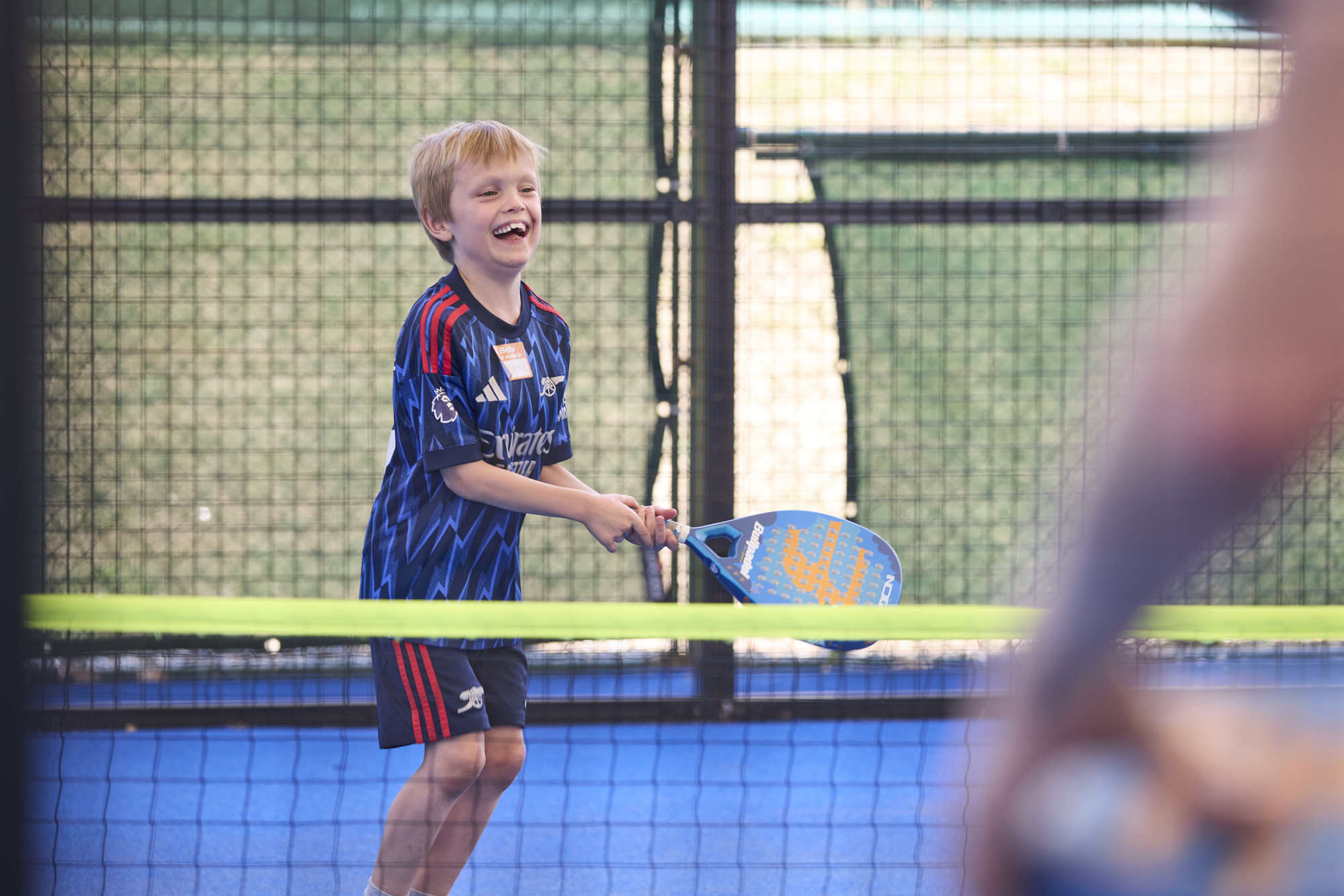 young boy smiling playing padel