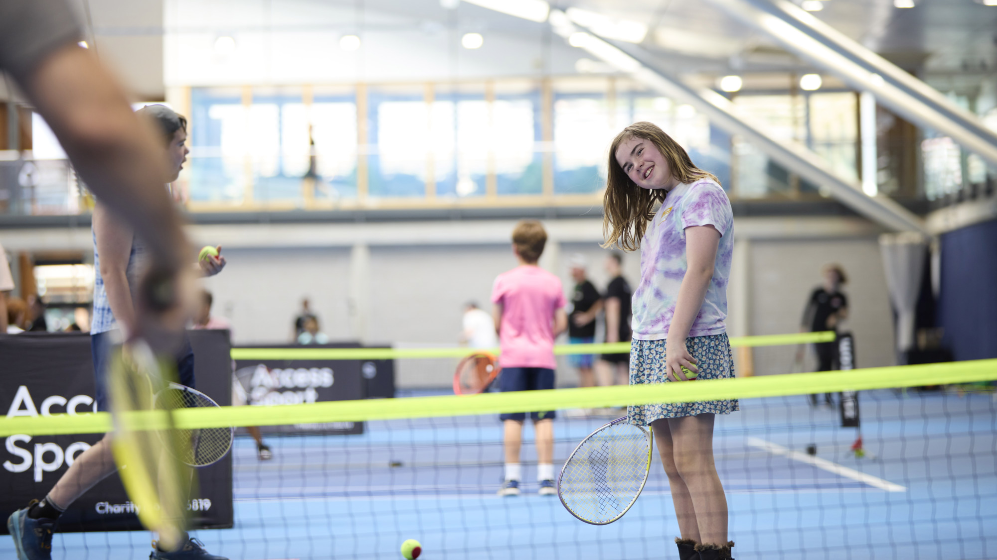 young girl smiling playing tennis