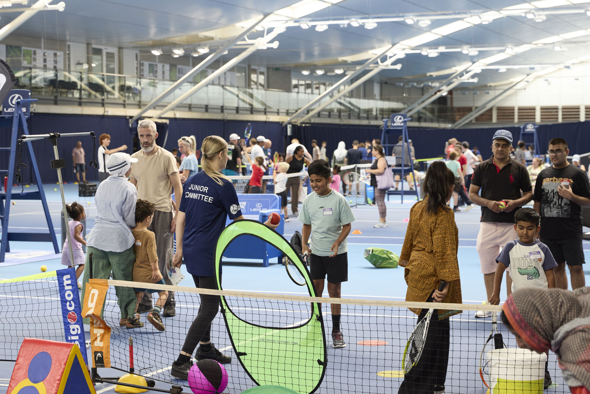 a large group of people playing various tennis activities on court