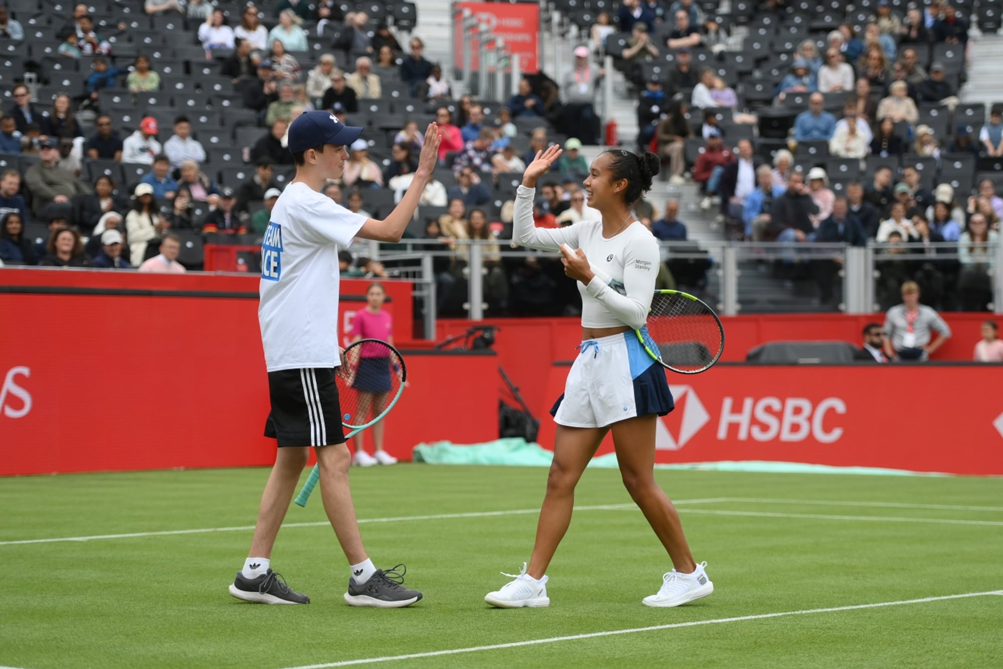 Leyla Fernadez giving young person a high five on centre court