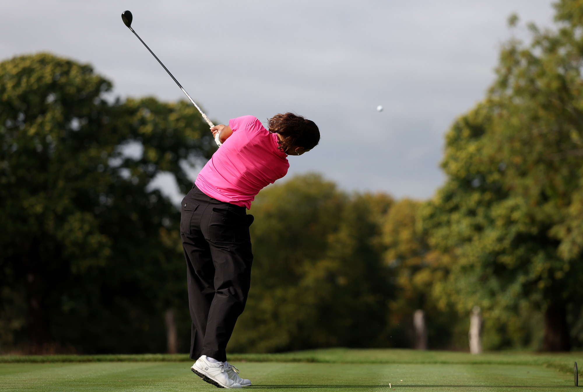 A golfer tees off on the 10th hole