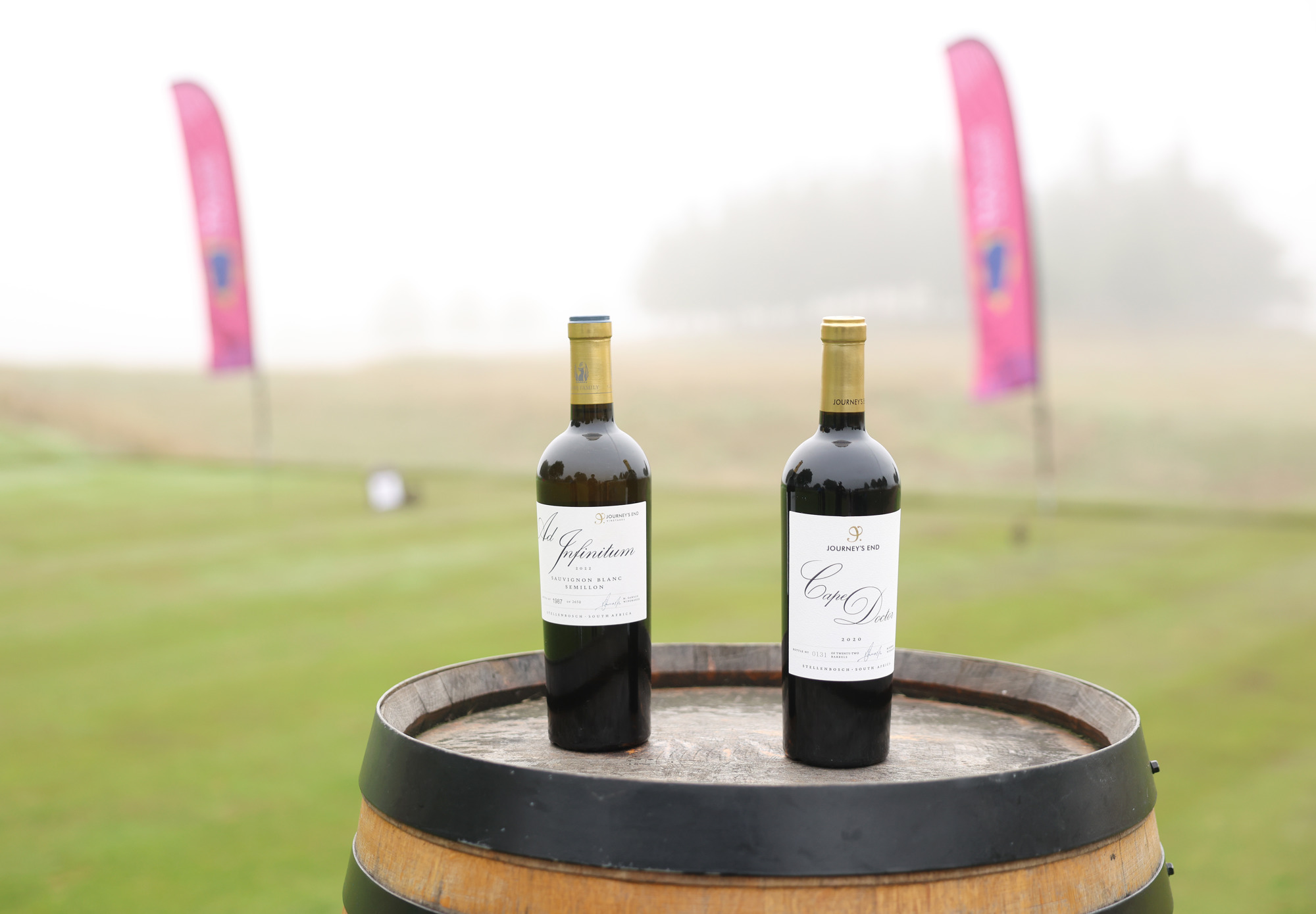 Two bottles of Journeys End wine sit on a barrel