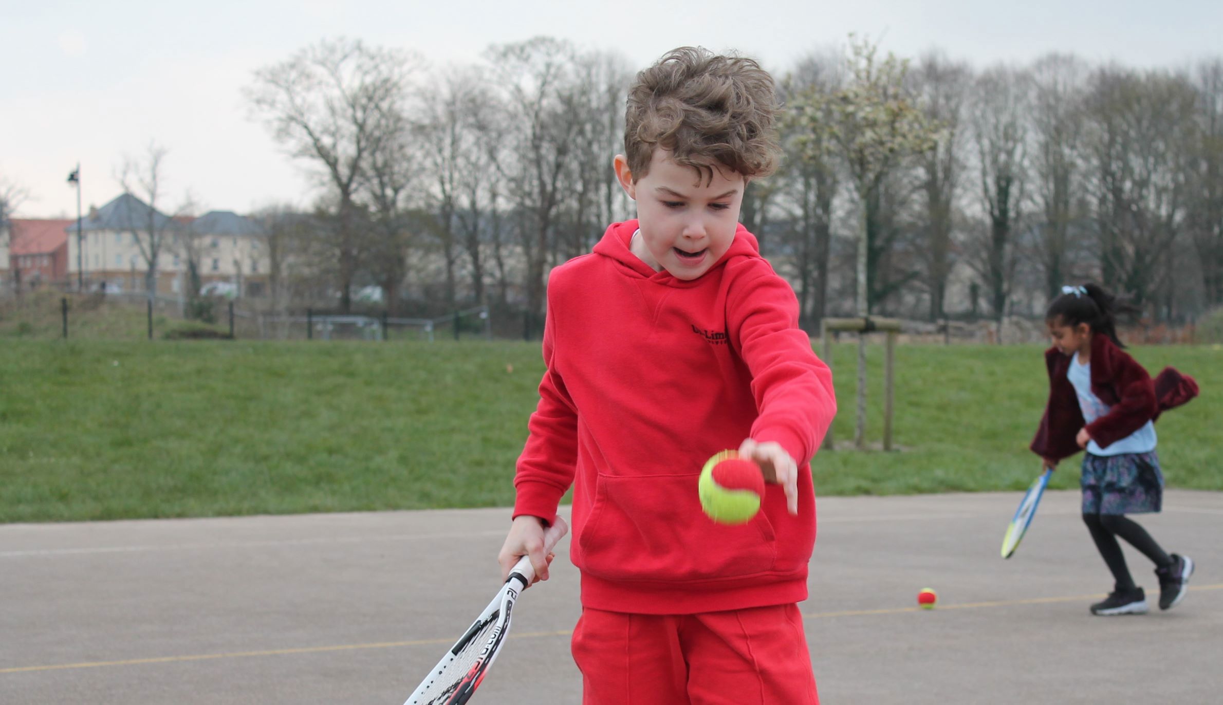 Primary school student enjoying tennis session 